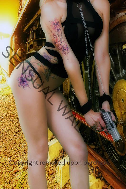 beautiful woman body tattooed wearing leather holding pistol