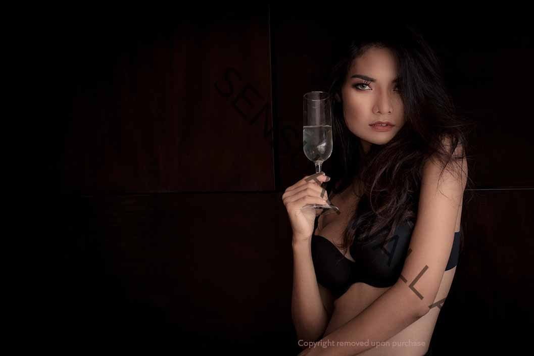 Woman wearing bra holding champagne glass